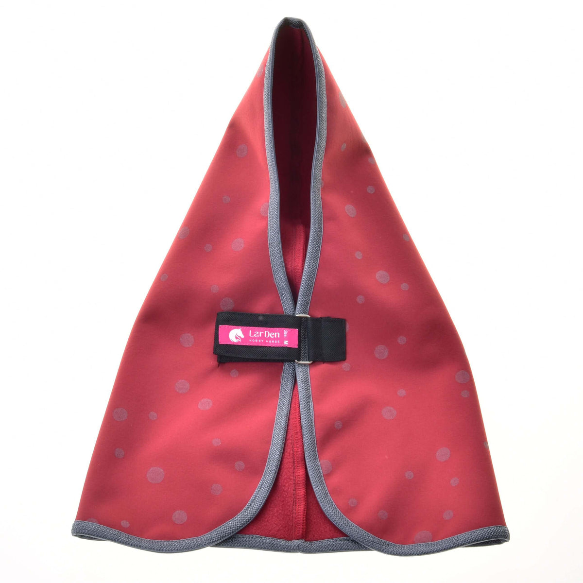 Front view of the raspberry red dotted stable blanket with the chest strap closed, LarDen label and fleece lining