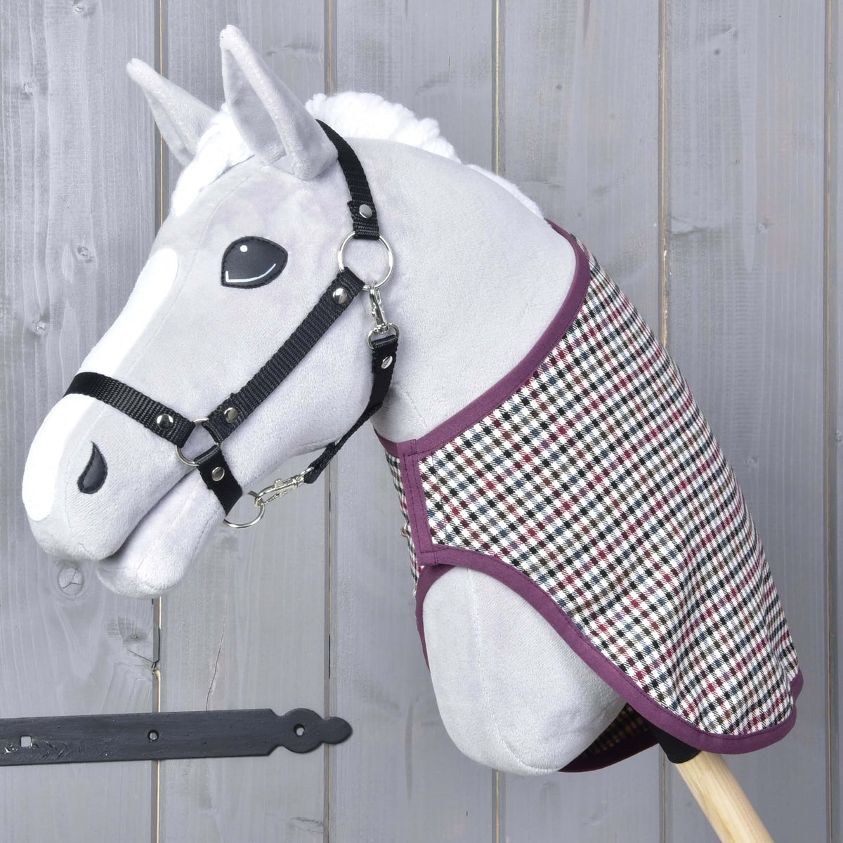 Grey plush Hobby Horse in a black halter wearing the Blanket western Colorado over its neck, plum edging