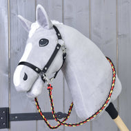 Lichtgrijze Hobby Horse met zwart halster en gevlochten zwart-rood-gele Teugels Flag om de hals