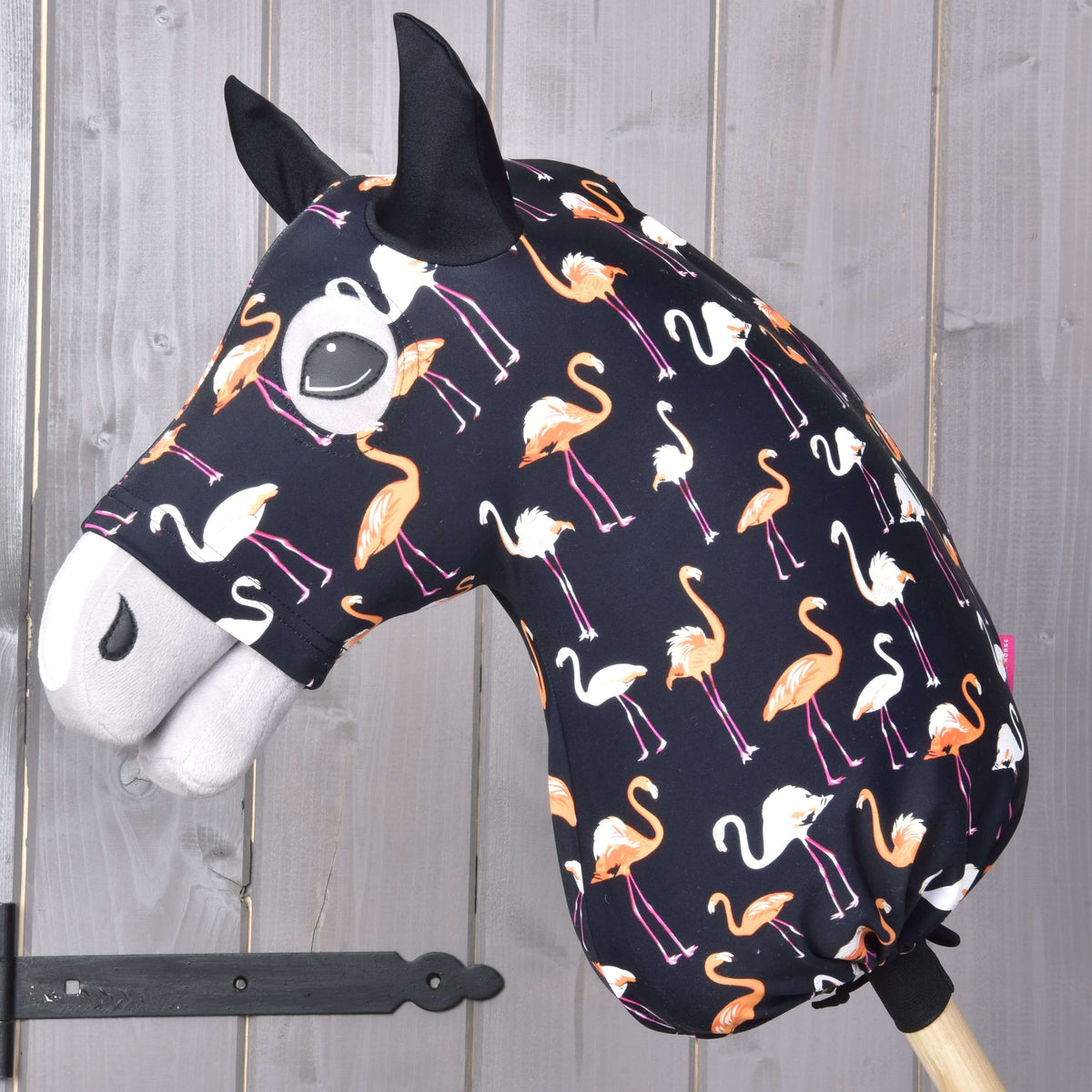 Beschermpak Lycra Flamingo van LarDen voor Hobby Horse op een grijs hoofd, zwart met oranje en witte flamingo’s en zwarte oren