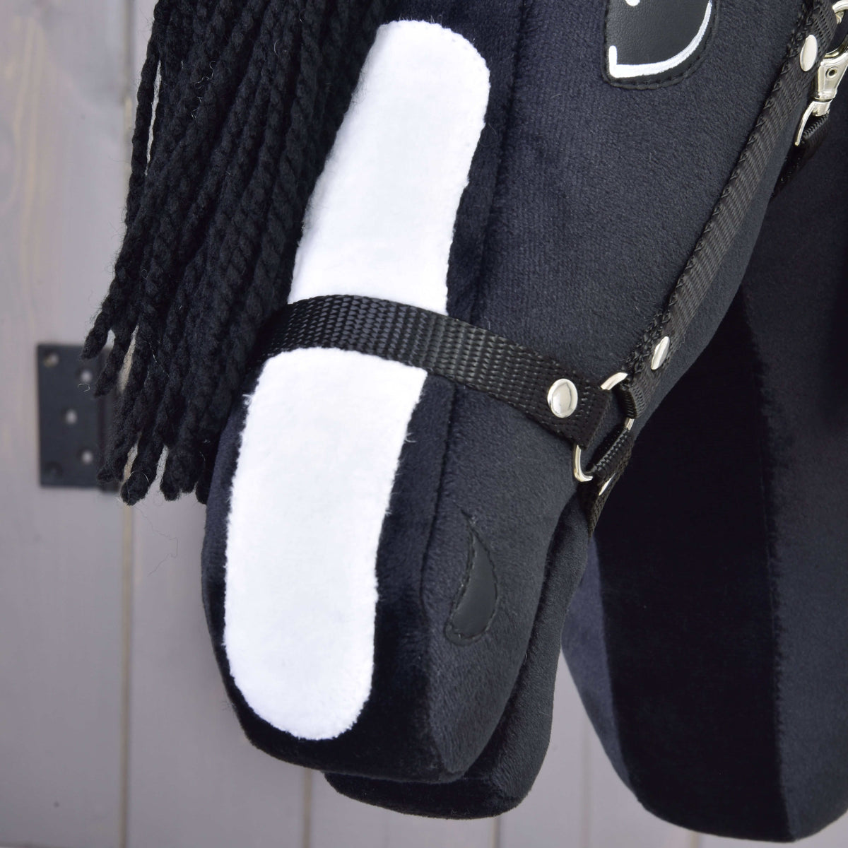 Close-up of the white blaze on the black plush muzzle of Hobby Horse Freya under the black halter noseband