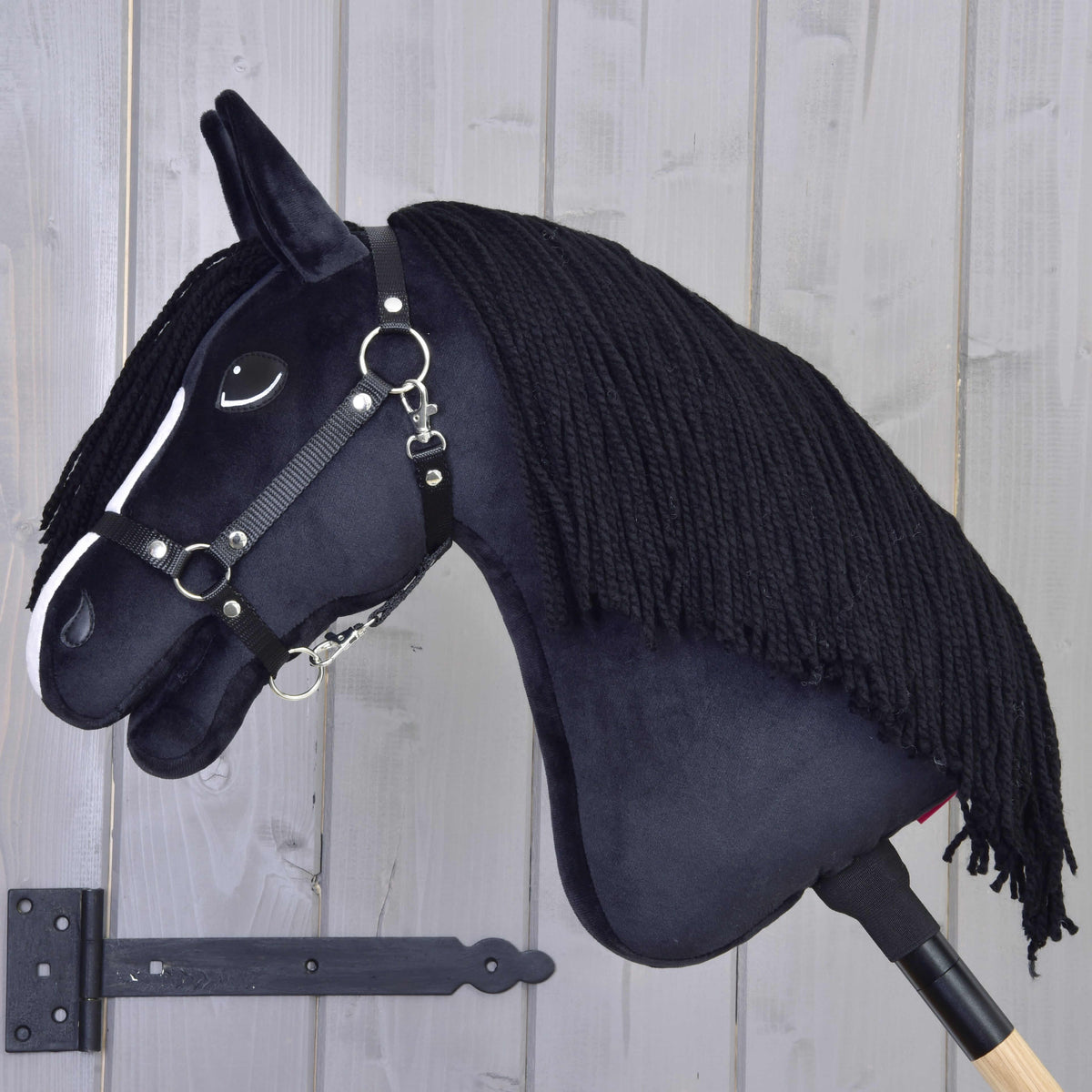 Hobby Horse Freya in left profile with a long black yarn mane covering the neck and a black halter