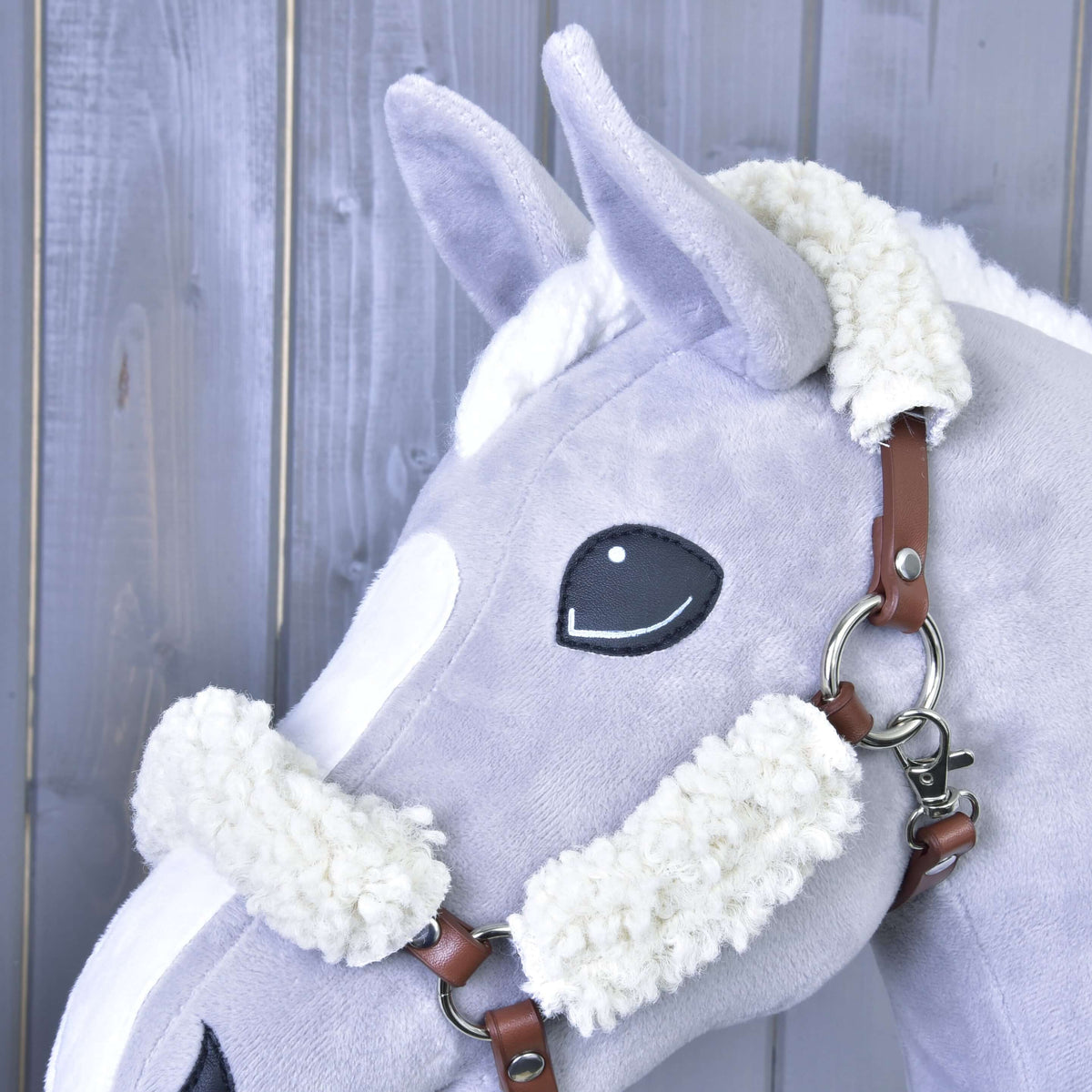 Fluffy fur on the noseband and crown of the brown halter on a light grey Hobby Horse, with silver ring and snap hook