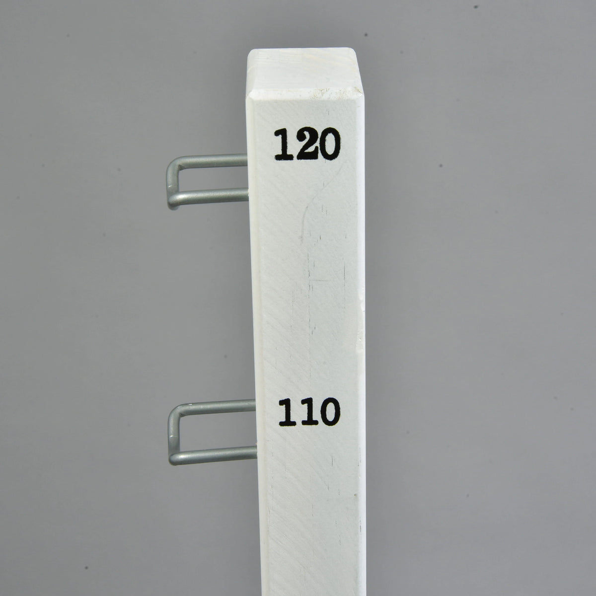 Close-up of the Hobby Horse jump: top of a white wing with height marks 110 and 120 and two metal pole holders