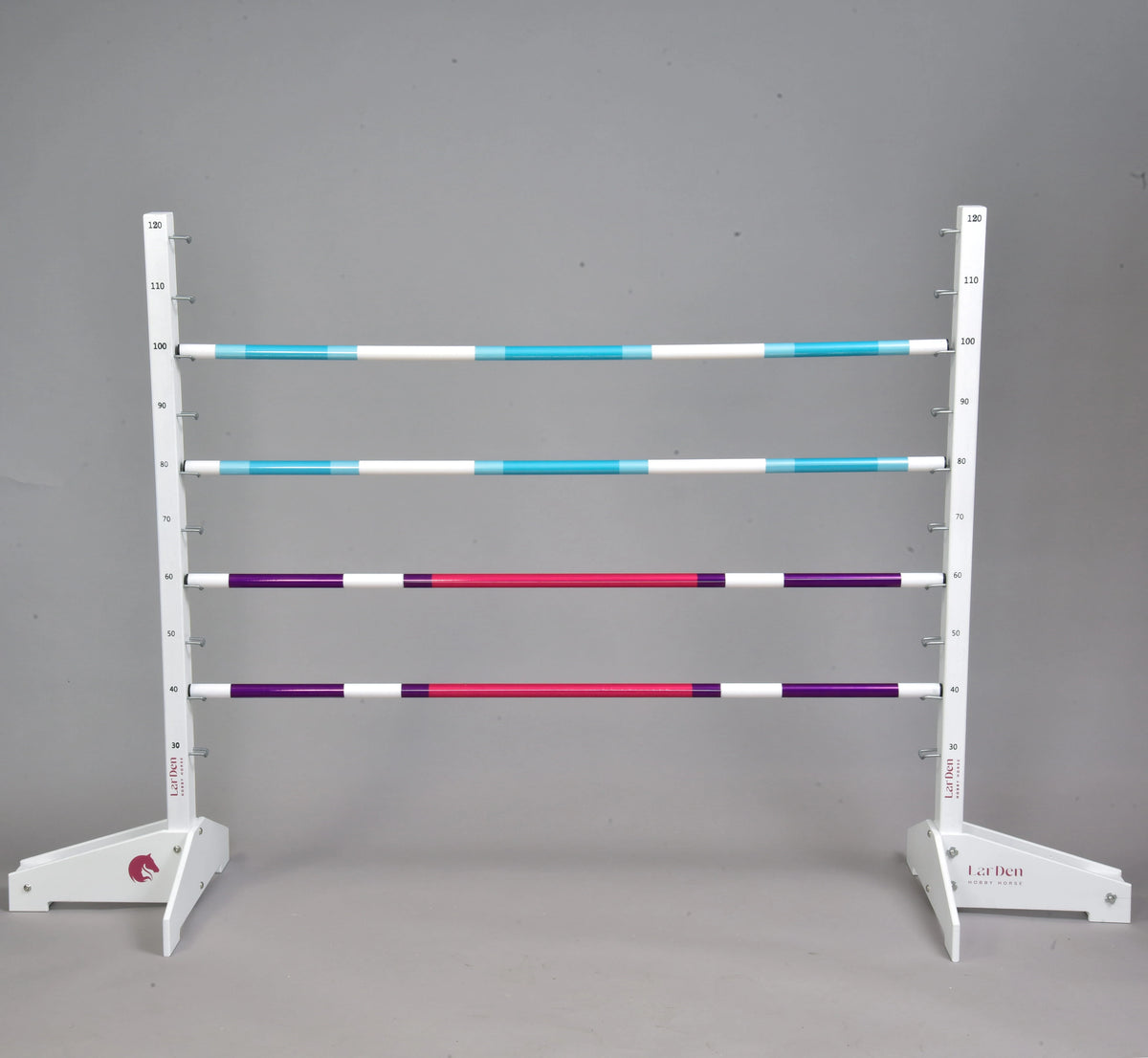 Jump with all four poles set up: two turquoise and white poles above two purple, pink and white poles between white wings