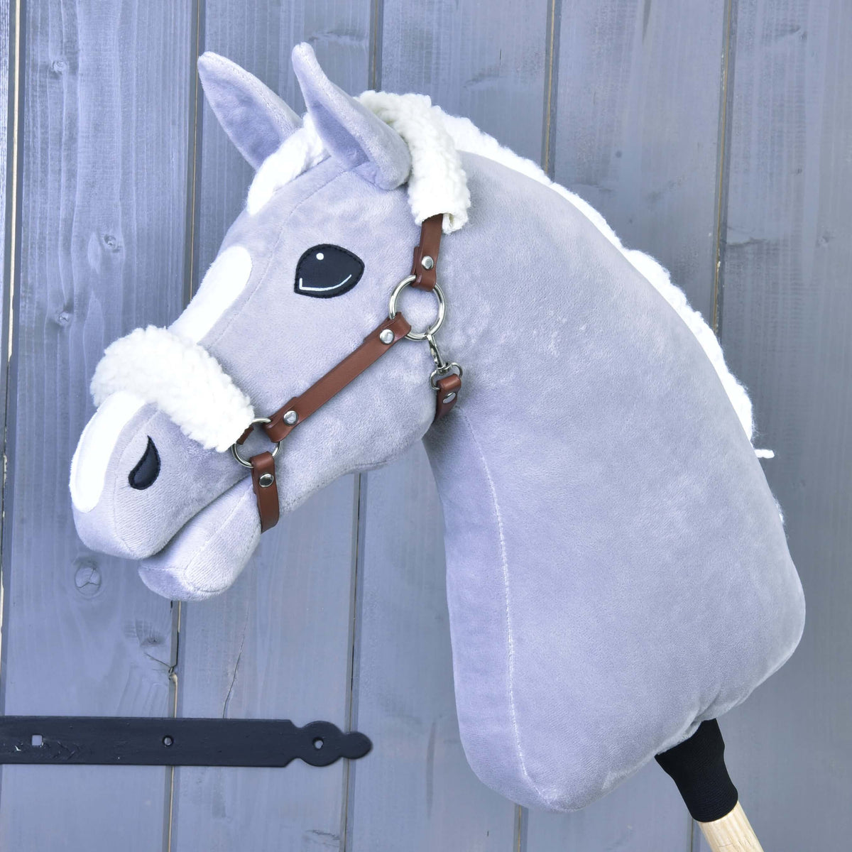 Grey Hobby Horse with a white mane wearing the cognac brown halter with white fur on the crown and front of the noseband