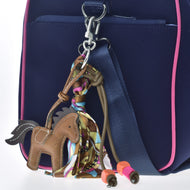 Sleutelhanger Paard Bruin aan een marineblauwe tas met roze bies, bruine koordjes en kleurrijke sjaal om de karabijnhaak