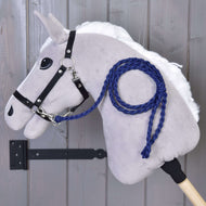 Grijze Hobby Horse met witte manen en zwart halster, het koningsblauwe gevlochten halstertouw vastgeklikt en over de hals gelegd