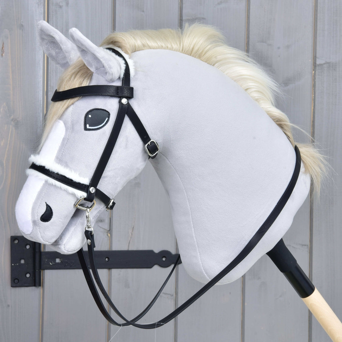 Hobby Horse Complete bridle with fur by LarDen, black with a white fur noseband and reins, on a grey plush head
