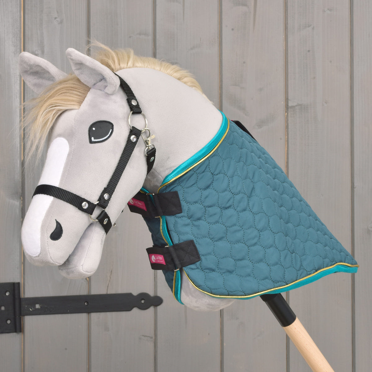 De deken Lagoon zonder halsstuk op een grijze Hobby Horse, met turquoise rand en gouden bies bij de hals