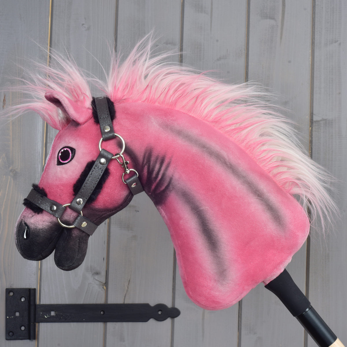 Hobby Horse Pinkie met een glinsterend halster van links, roze-witte manen van imitatiebont en zwarte gespoten strepen op de hals