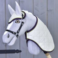 Hobby Horse gris aux yeux ambre avec licol noir portant l’ensemble Leonardo, matelassage ivoire bordé de violet et de vert