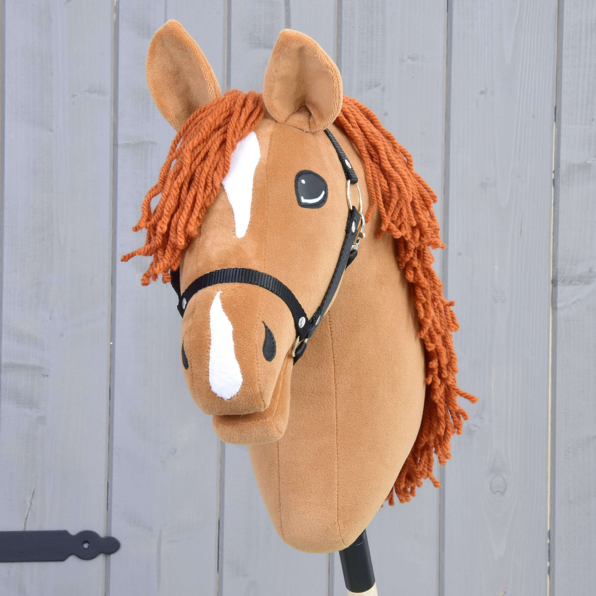 Front view of Hobby Horse Little Angel with a white star, white stripe on the nose and copper yarn forelock
