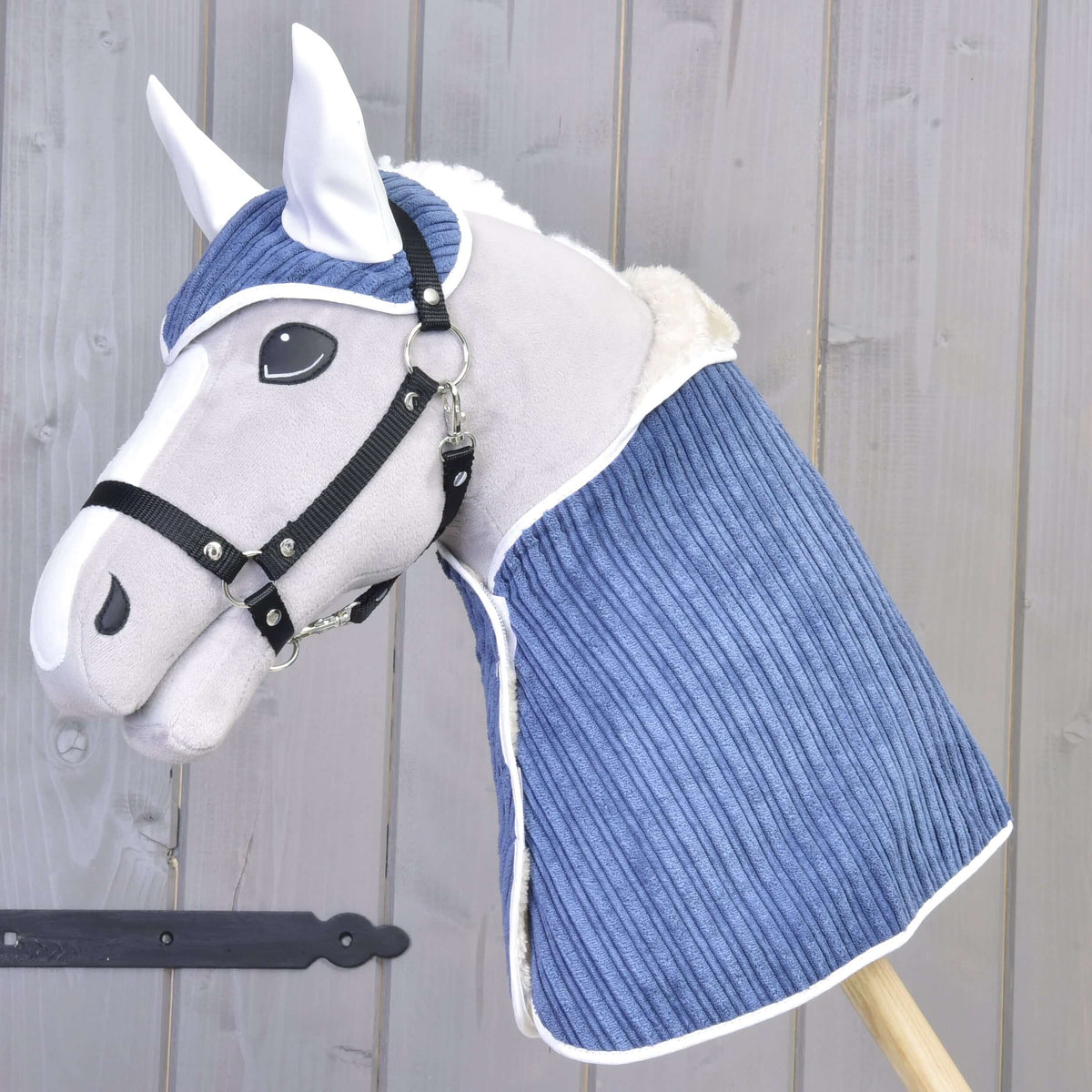 Hobby Horse gris clair portant l’ensemble Manchester Plum, bonnet d’oreilles et couverture en velours côtelé bleu à liseré blanc