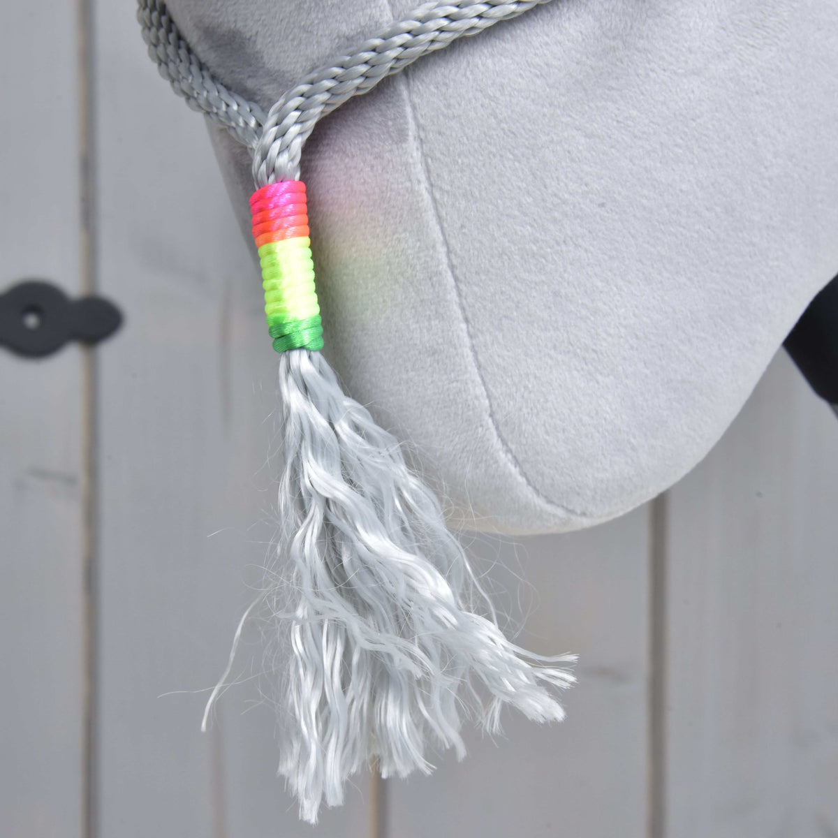 Close-up of the grey rope tassel of Rope set Manhattan with a neon pink, yellow and green wrap, hanging below the jaw