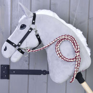 Bordeauxrood en crème gevlochten halstertouw aan het zwarte halster van een grijze Hobby Horse voor een grijze houten wand