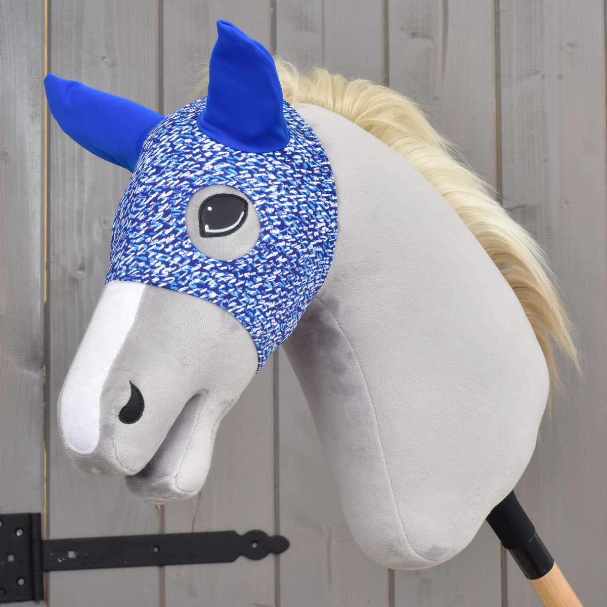 Paardenmasker See van LarDen op een grijze Hobby Horse met blonde manen: blauw-wit gespikkelde stretchstof met koningsblauwe oren