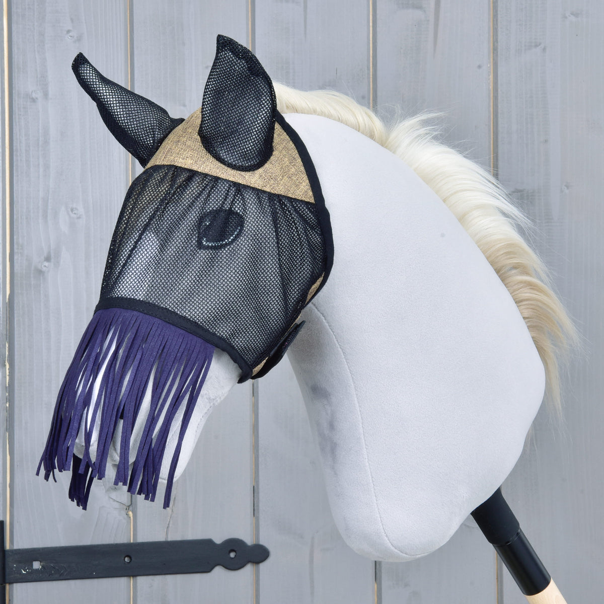 Vliegenmasker De Luxe Mona van LarDen van zwart gaas met beige geweven voorhoofdstuk en donkerpaarse neusfranjes op een grijze Hobby Horse