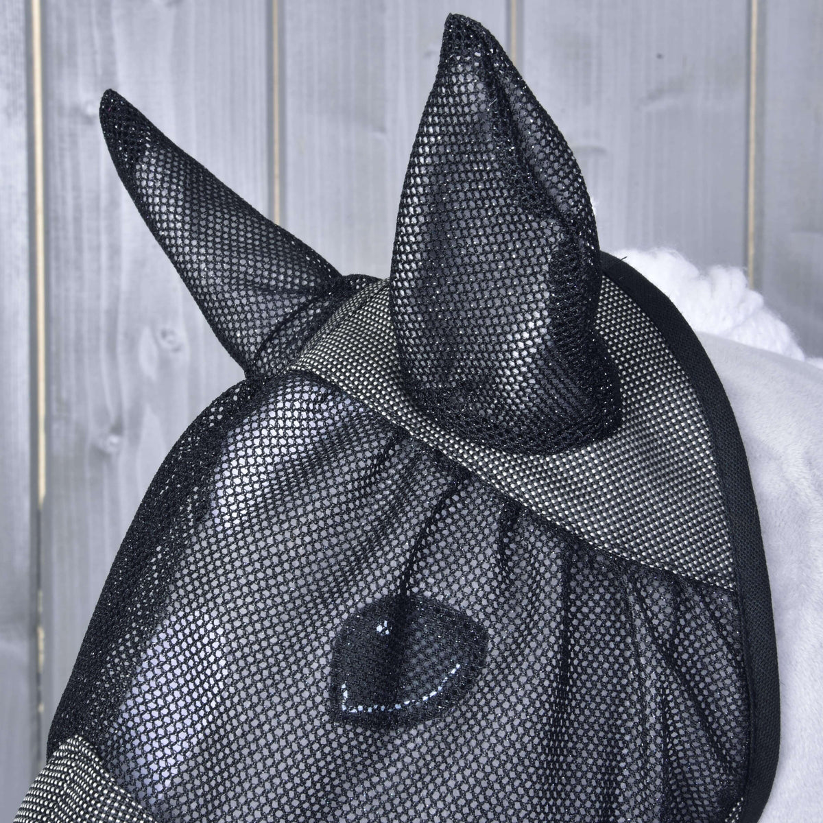 Gros plan des oreilles et du filet des yeux en maille noire du masque anti-mouches De Luxe Gris pour Hobby Horse, l’œil visible dessous