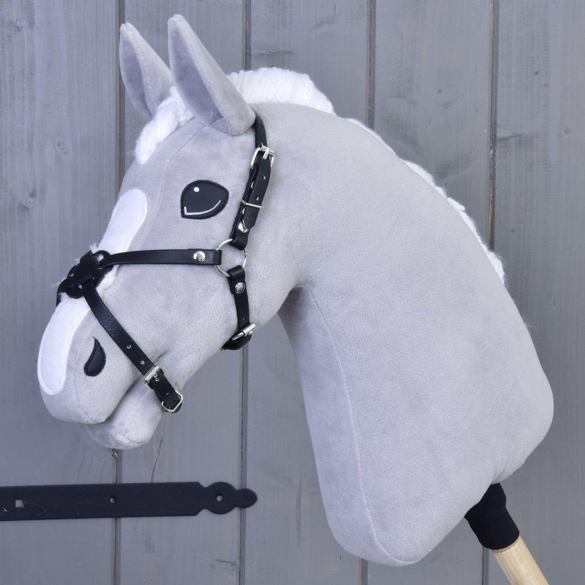 Muserolle Mexico noire rembourrée de LarDen sur un Hobby Horse gris en peluche, sanglettes en similicuir noir croisées sur le nez