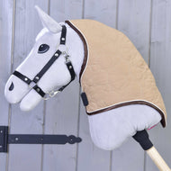Grijze Hobby Horse met zwart halster draagt de beige halsbeschermer met hartjesstiksel en bruine rand