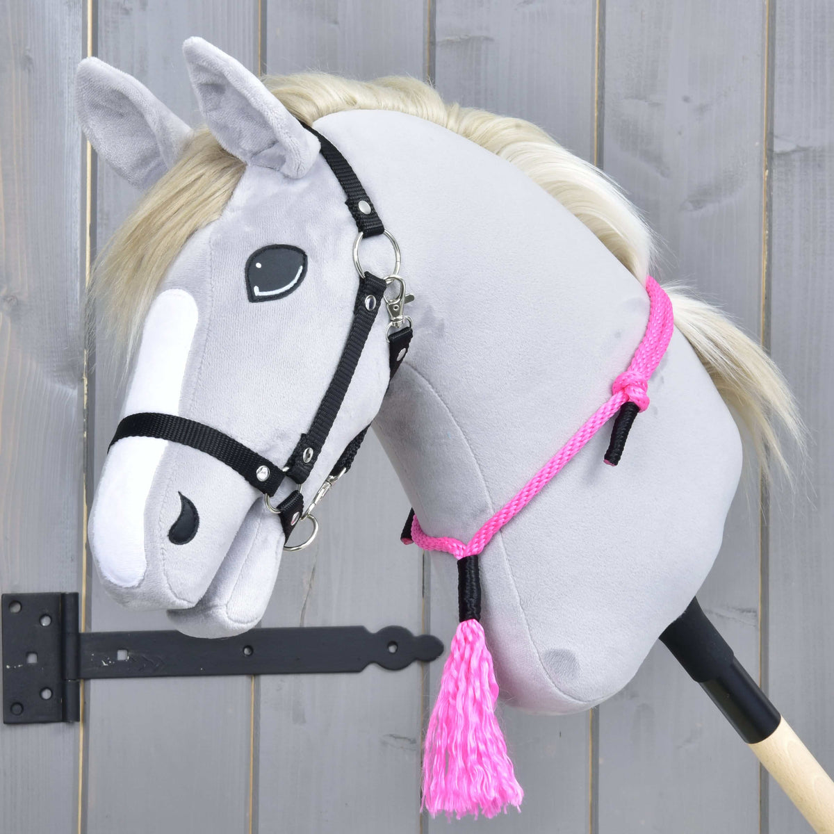 Hobby Horse gris à crinière claire et licol noir portant le cordéo Pink Festive autour de l’encolure, avec pompon rose