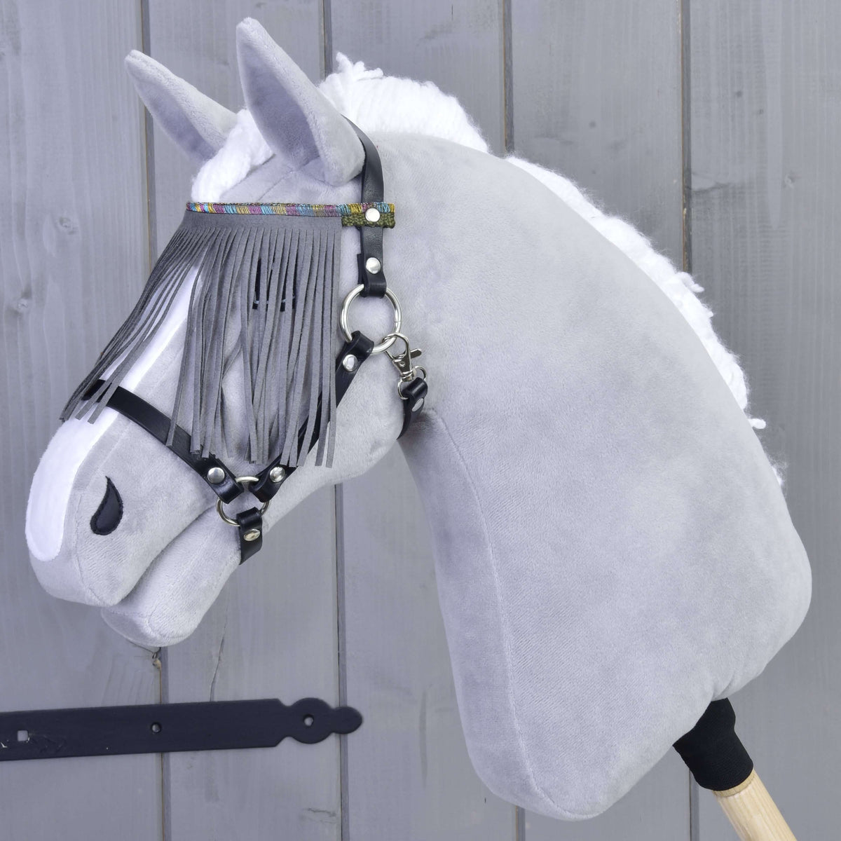 Grijze pluche Hobby Horse met het halster zwart met grijze franjes van LarDen, de franjes vallen over de ogen