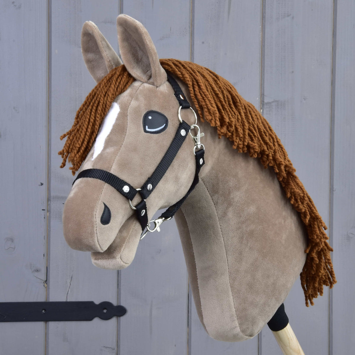 Hobby Horse Oliver in light brown plush with a white stripe, brown yarn mane and black halter, seen at an angle