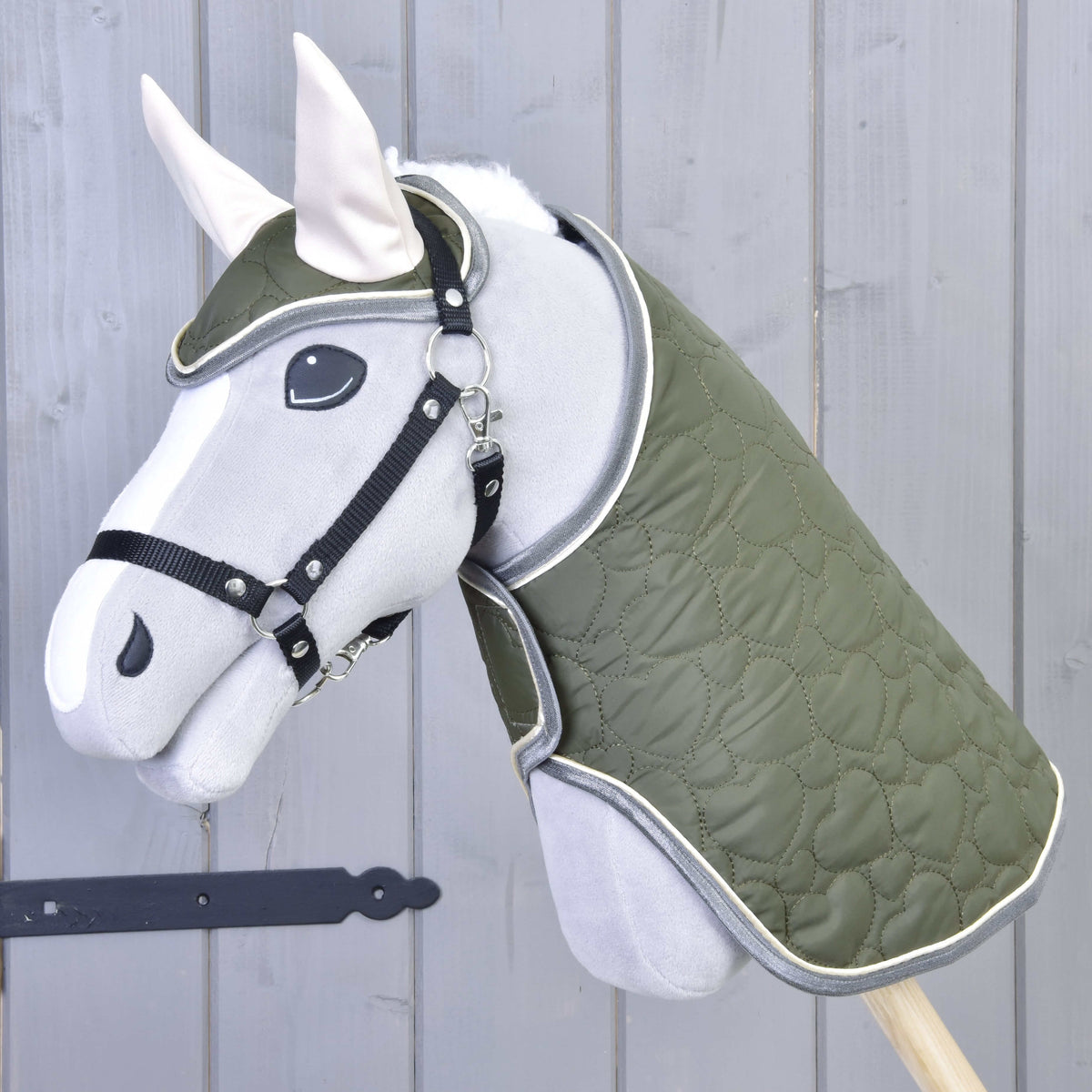 Ensemble Olivetti sur un Hobby Horse gris en peluche : couverture olive matelassée, bonnet d’oreilles aux oreilles crème, licol noir