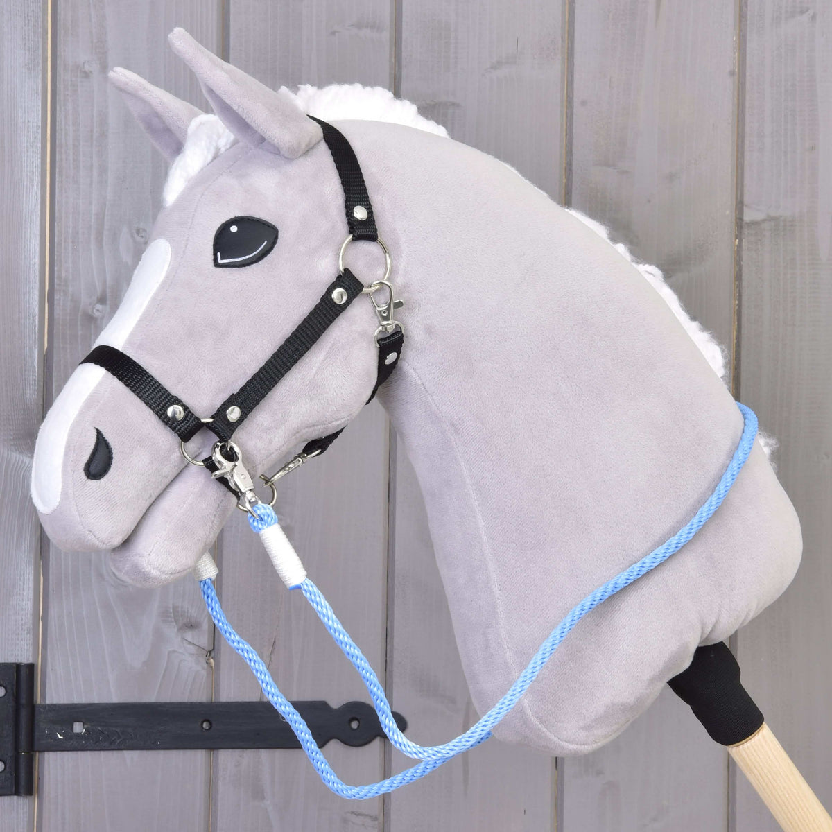 Grey Hobby Horse with a black halter and the light blue rope reins clipped on and draped over its neck