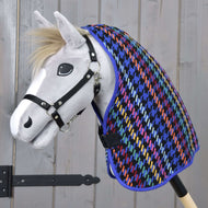 Hobby Horse gris à crinière blonde et licol noir portant la couverture d’écurie Peru pied-de-poule multicolore sur l’encolure