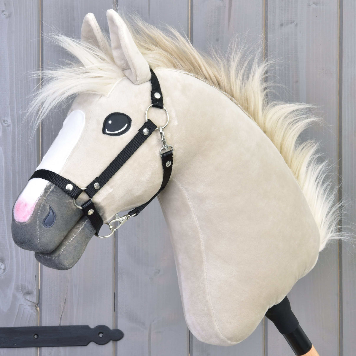 Hobby Horse Pixie met zwarte halster van LarDen, crèmekleurig pluche hoofd met witte bles, grijze neus en golvende lichte bontmanen