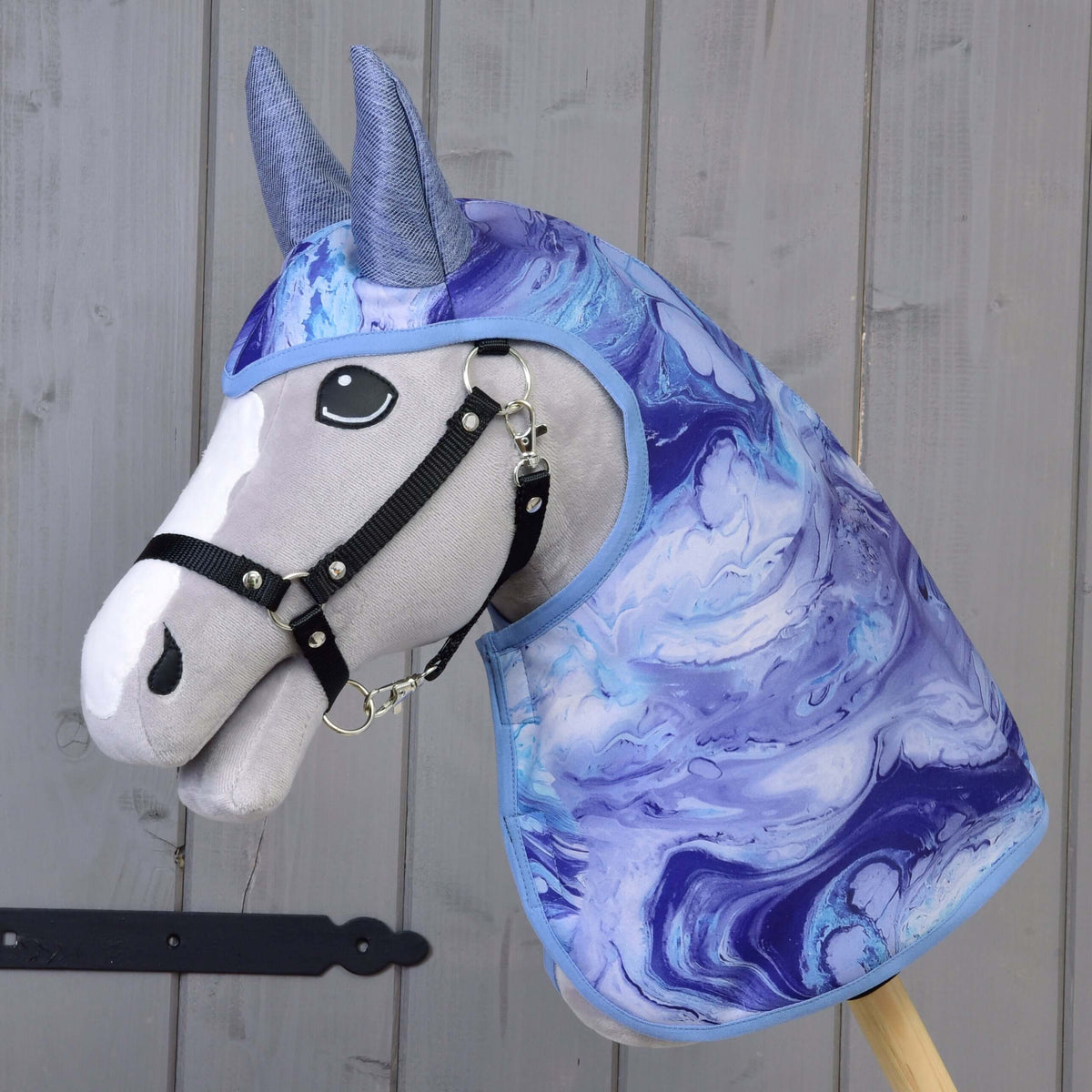 Grijze Hobby Horse met zwart halster in de regenjas Galaxy Blue met blauw-paars marmerpatroon en blauwgrijze oren