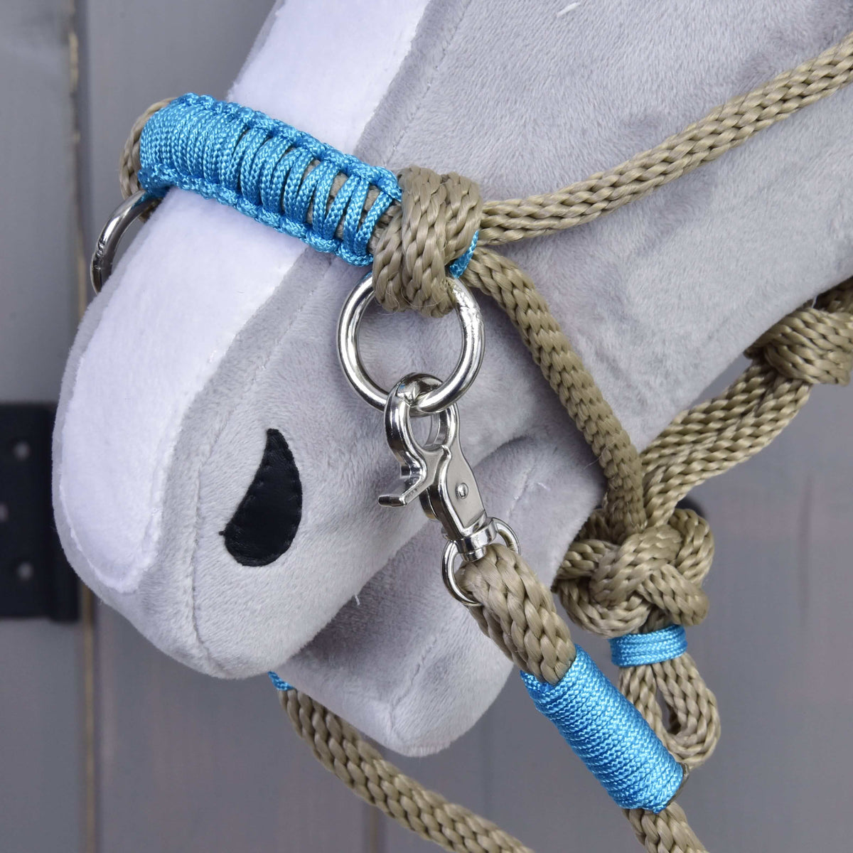 Close-up of the Hobby Horse Rope set Nature Blue noseband: blue braided wrap, beige rope knots, silver ring and snap hook
