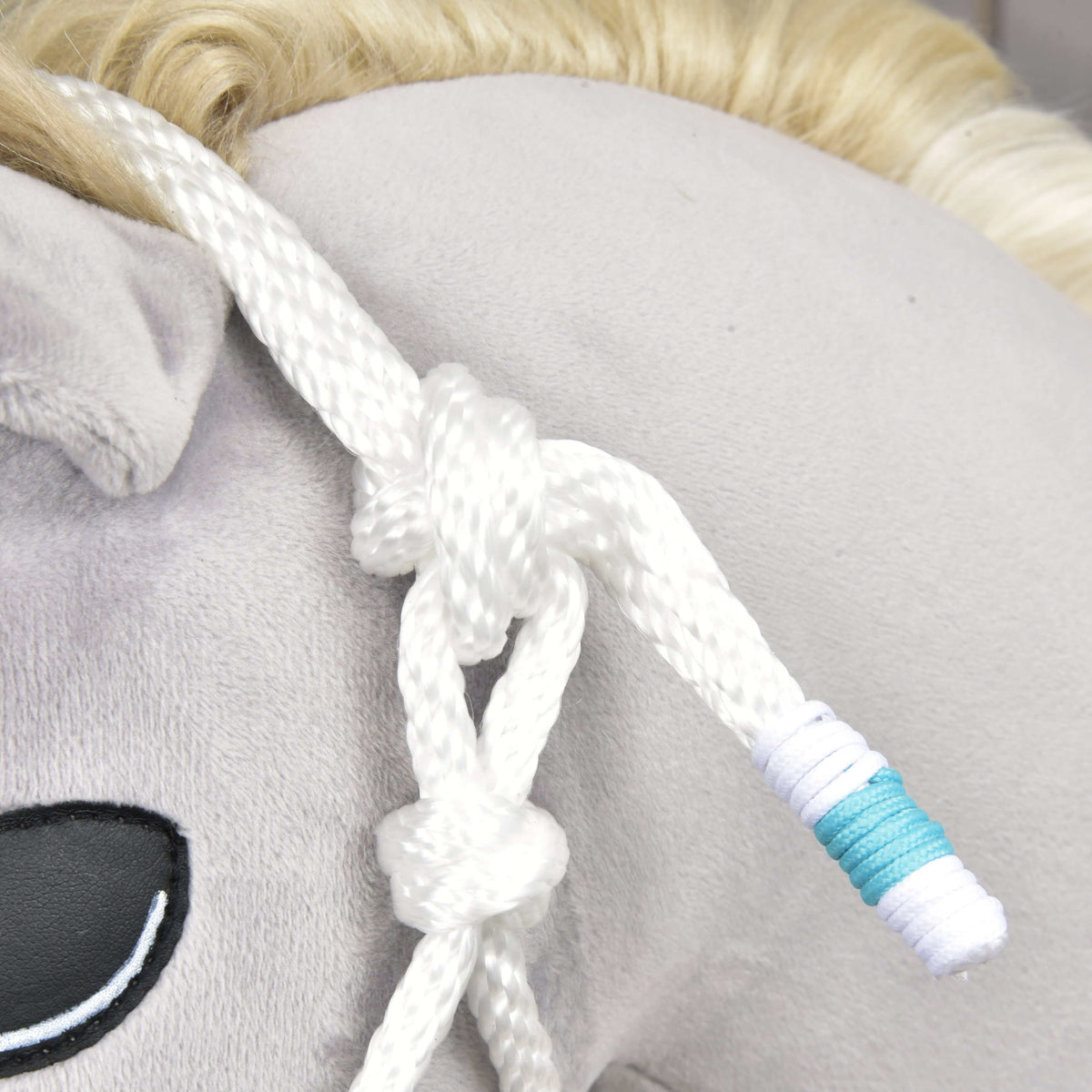 Knopen in het witte touw van de Touwset White Queen bij het oor, het uiteinde afgewerkt met turquoise en witte omwikkeling