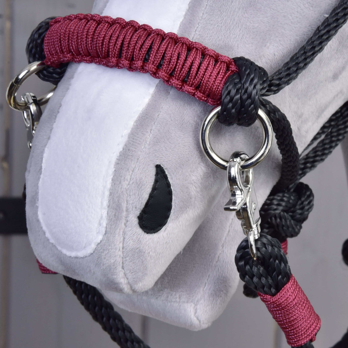 Gros plan sur la muserolle tressée bordeaux de l’ensemble de corde Maroon pour Hobby Horse, corde noire, anneau et mousqueton