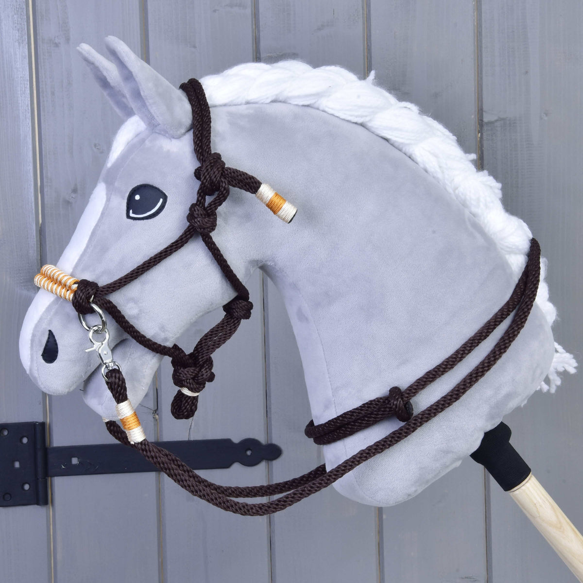 Grijze Hobby Horse met witte gevlochten manen in de Touwset Oranje: donkerbruin touwhalster en teugels met oranje wikkels