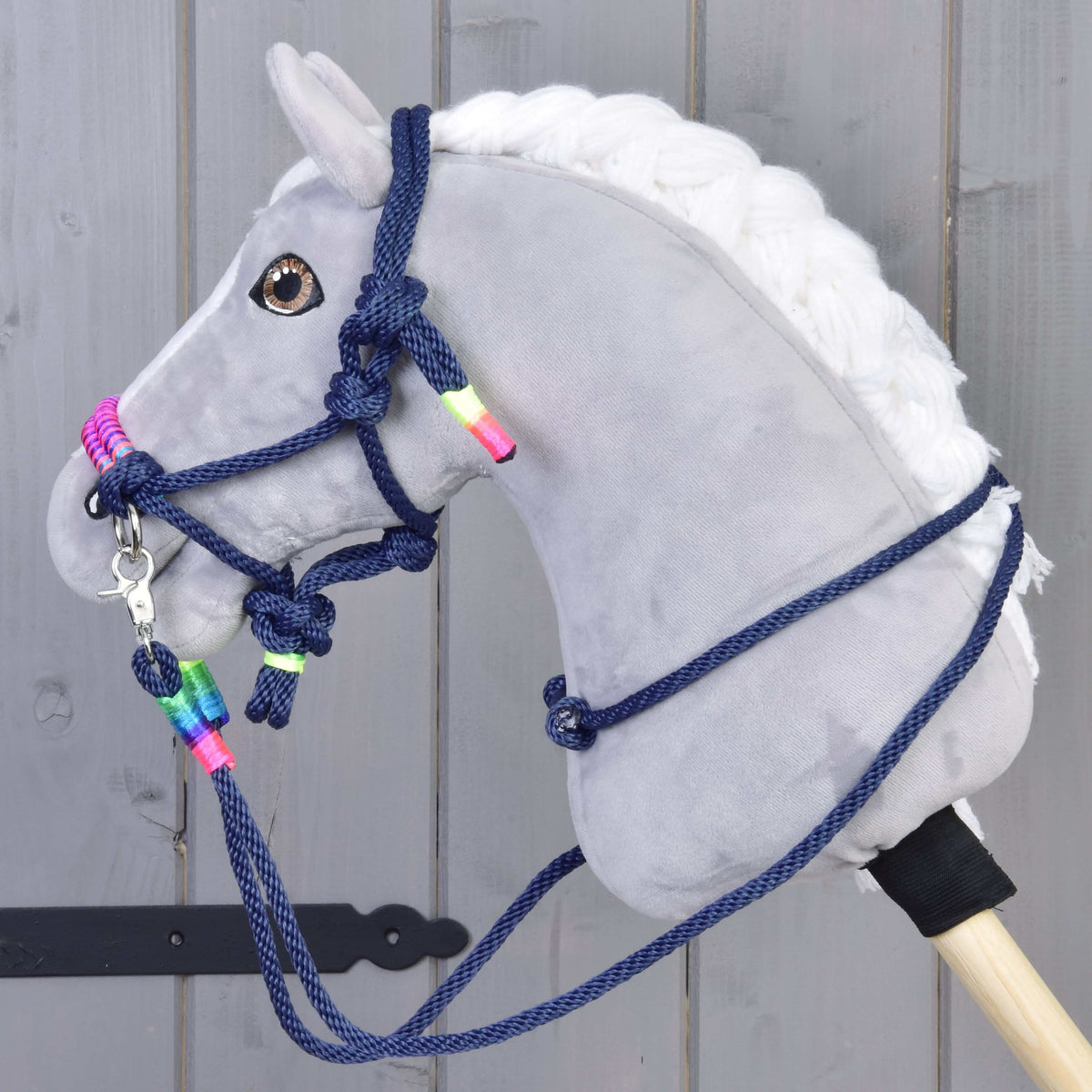 Grijze Hobby Horse met bruine ogen in de Touwset Rosemary: marineblauw touwhalster en teugels met neon regenboogwikkels