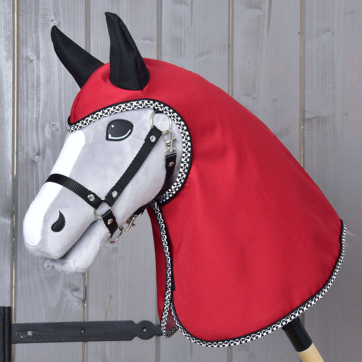Grijze Hobby Horse met zwart halster in de Regenjas Red Ferrari, rode kap en hals afgezet met zwart-witte bies
