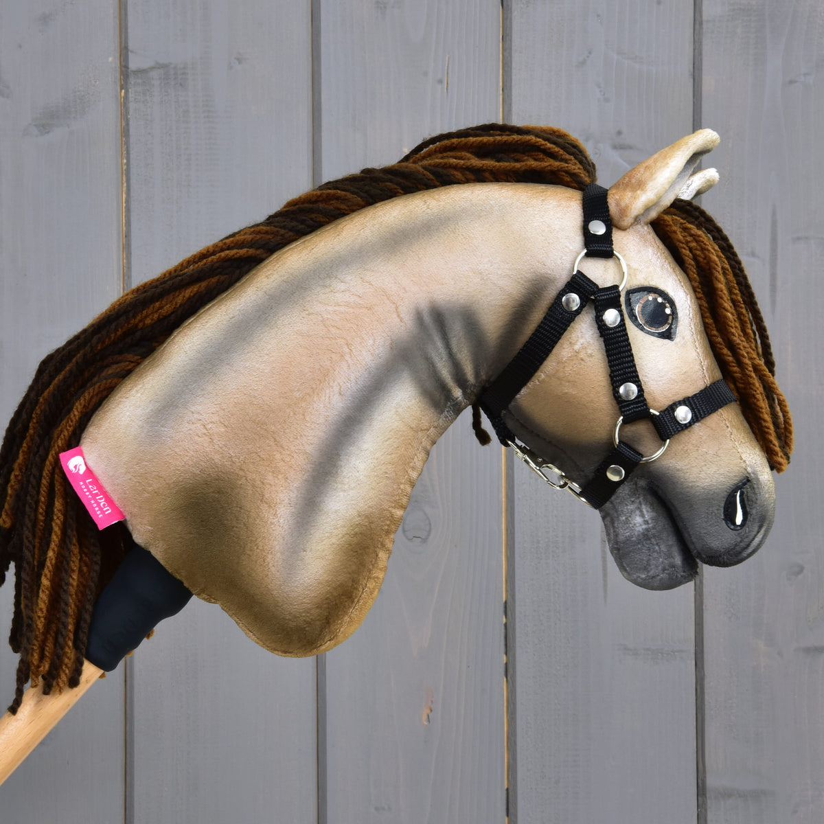 Hobby Horse Ruby tourné vers la droite, avec l’étiquette LarDen rose au bas de l’encolure et longue crinière en fil marron