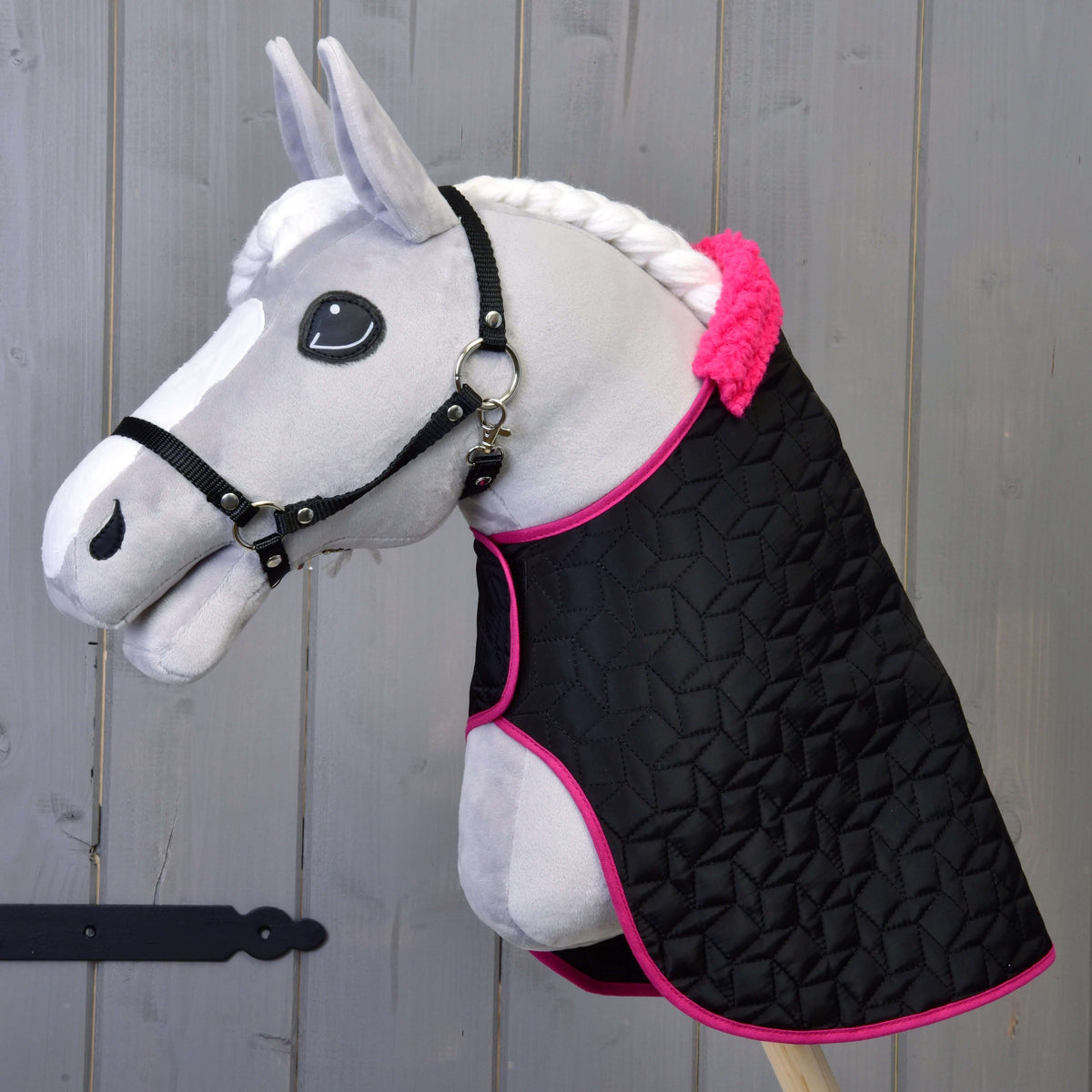 Hobby Horse gris avec licol noir portant seulement la couverture matelassée noire à bordure rose et col en fourrure rose