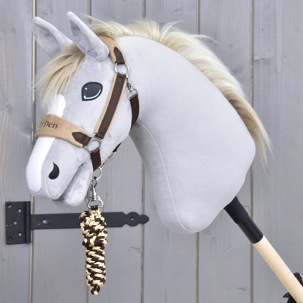 Licol Exclusive Brown sur un Hobby Horse gris à liste blanche, la longe tressée marron et crème enroulée sous le menton