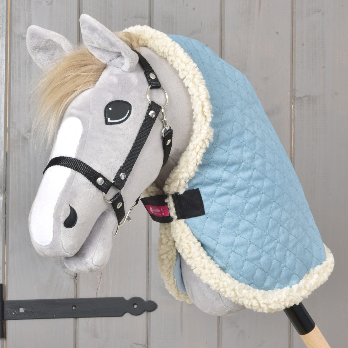 Grijze Hobby Horse met zwarte halster in de lichtblauwe doorgestikte staldeken Sky Blue met crème fleecerand