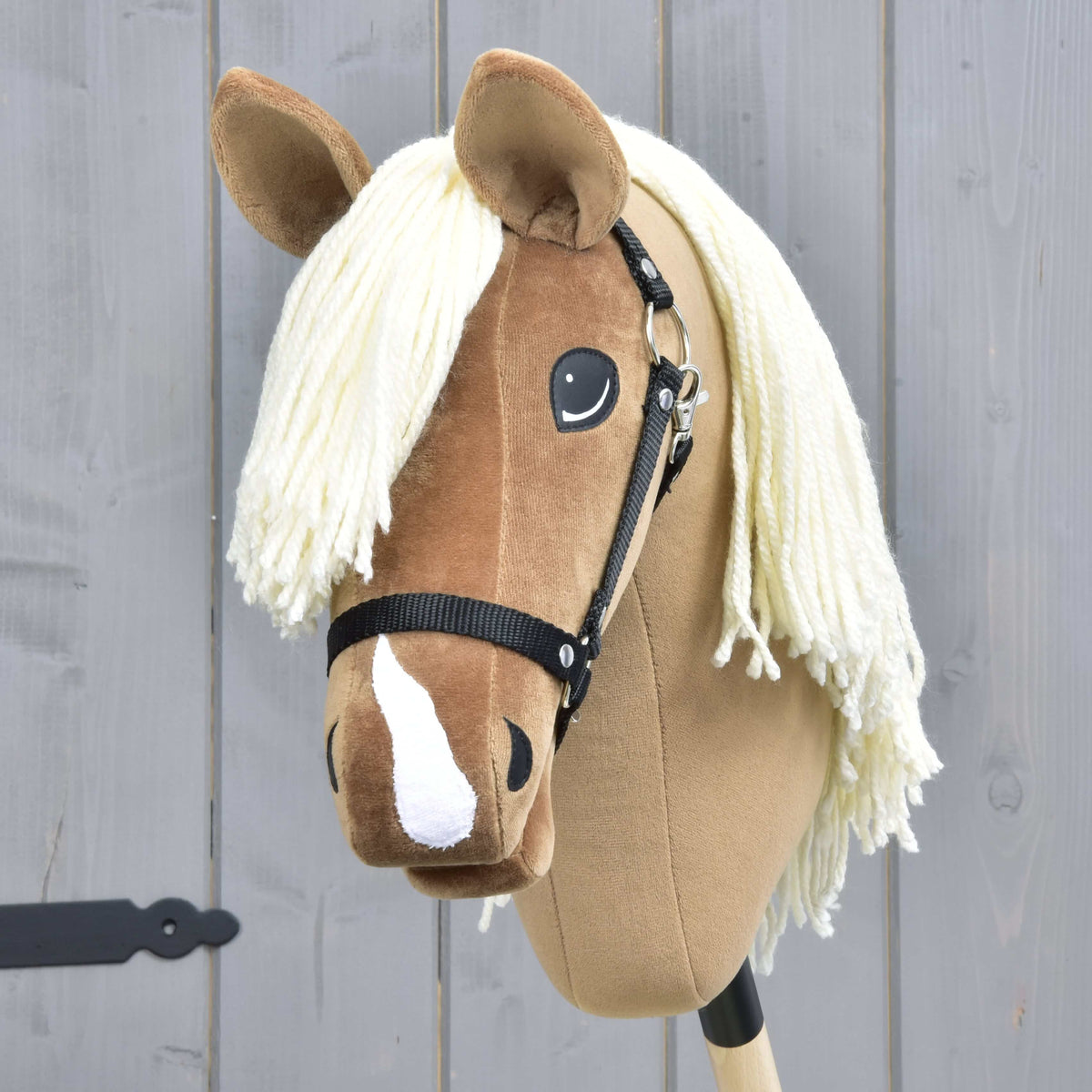 Vue de face du Hobby Horse Smart avec toupet en fil crème, nuances brun plus foncé sur la tête et bande blanche sur le nez