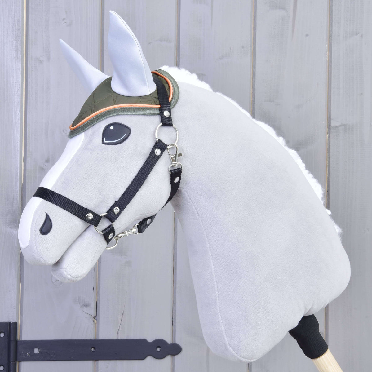 Grijze Hobby Horse met zwarte halster draagt het olijfgroene doorgestikte oornetje met lichtgrijze oren