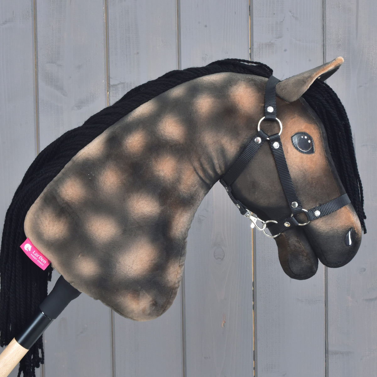 Hobby Horse Stormy avec licol noir vu de droite, pommelures claires sur l’encolure brune et étiquette rose LarDen
