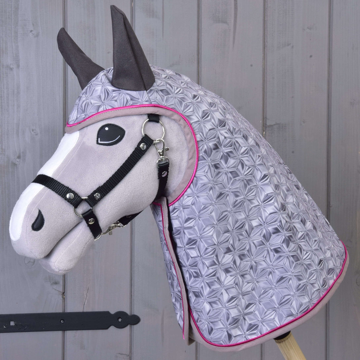 Hobby Horse gris en peluche portant l’imperméable Valentine à motif géométrique gris argent, passepoil rose vif et oreilles gris foncé