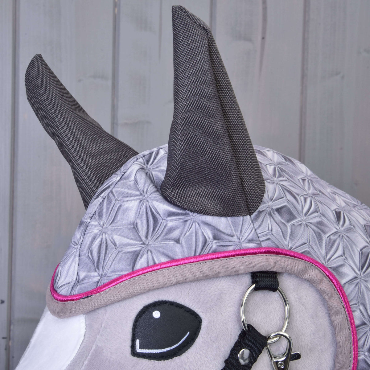 Gros plan sur les oreilles gris foncé et le motif géométrique chatoyant de la capuche de l’imperméable Valentine
