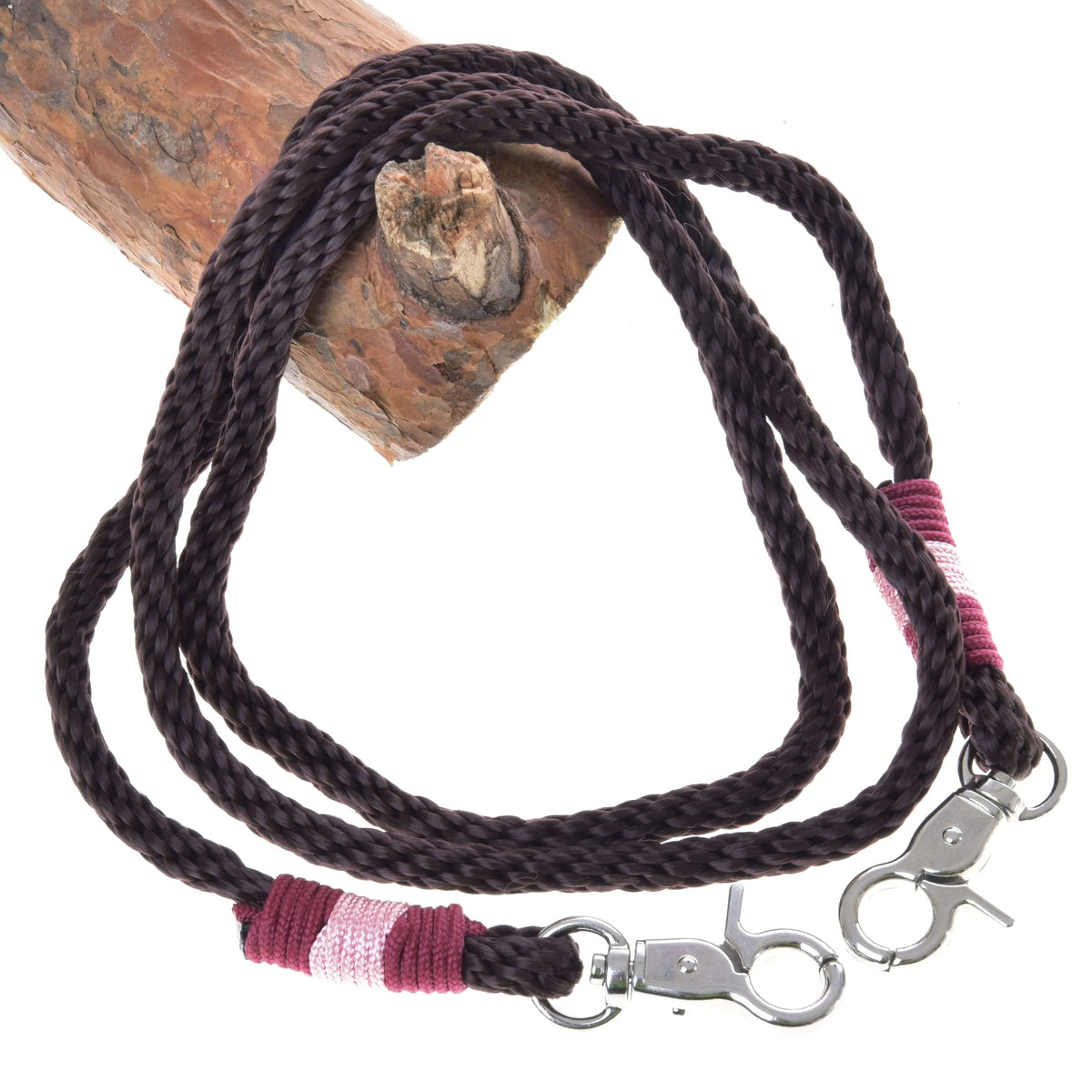 Hobby Horse Reins York by LarDen, dark brown rope reins with pink and burgundy wrapped ends and snap hooks, on a branch