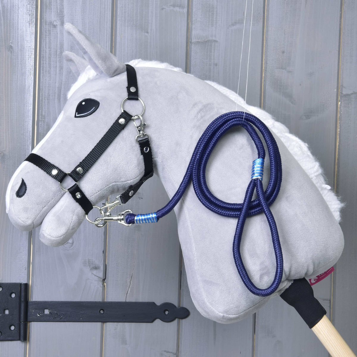 Hobby Horse gris clair avec licol noir et longe rayée Blues bleu marine posée sur l’encolure